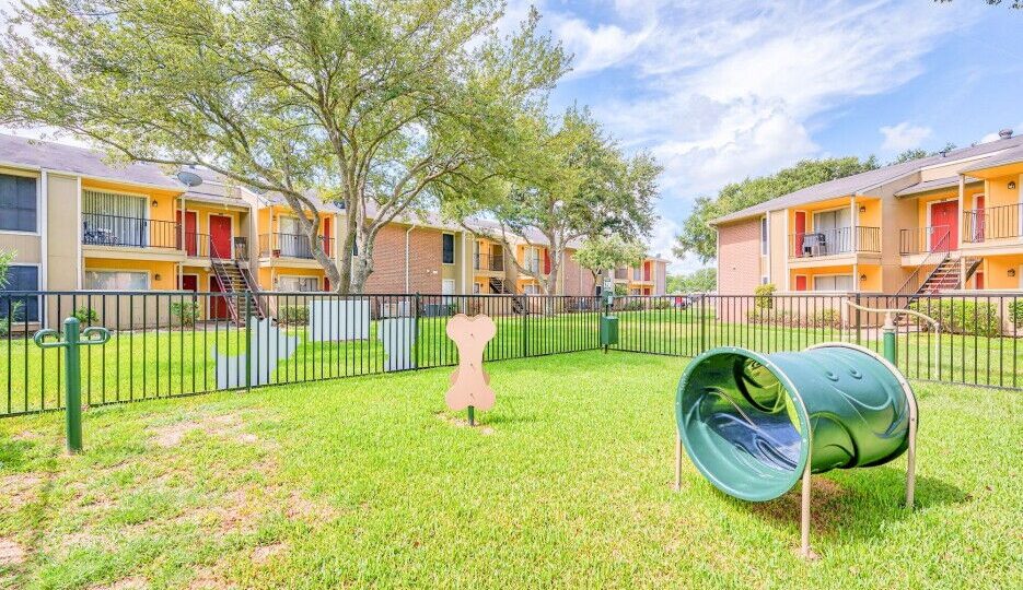 the green grass and trees in front of the apartment complex at The Del Sol