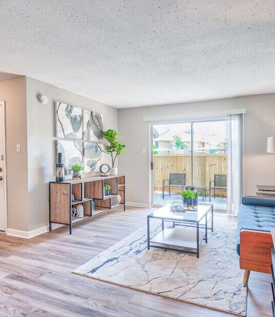 the living room has hardwood floors and a large window at The Del Sol