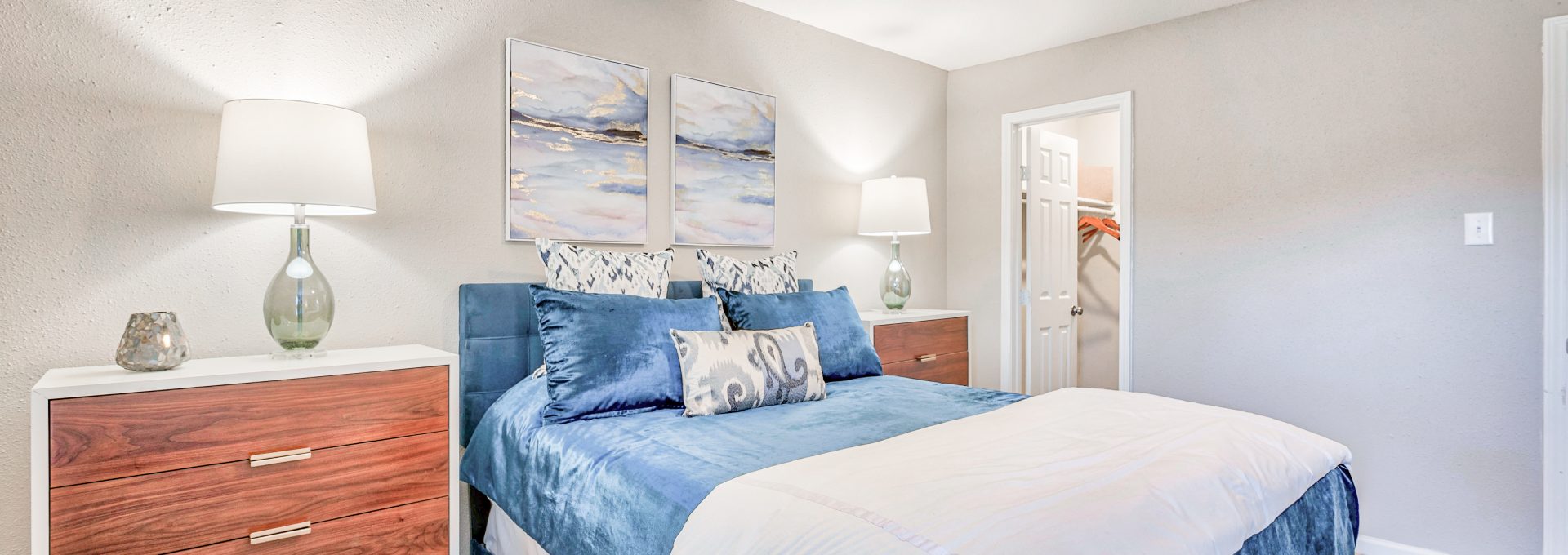 a bedroom with a blue bed and white dresser at The Del Sol