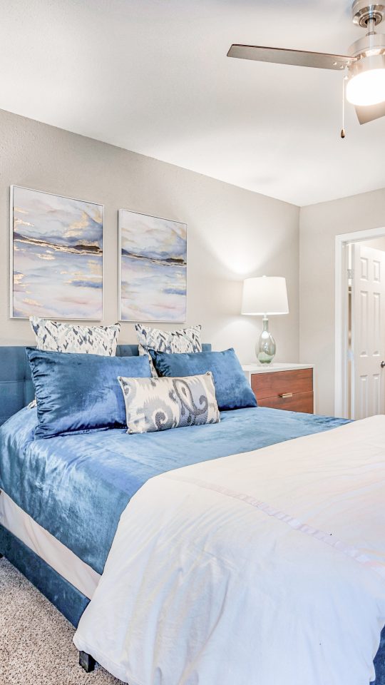 a bedroom with a blue bed and white dresser at The Del Sol